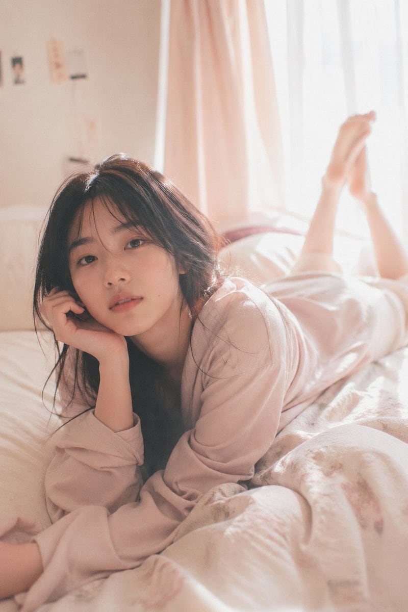 soft dreamy editorial aesthetic, diffused natural light, slight overexposure, soft highlight bloom, low contrast, pastel color tones, gentle pinkish warmth, subtle grain young japanese wo...