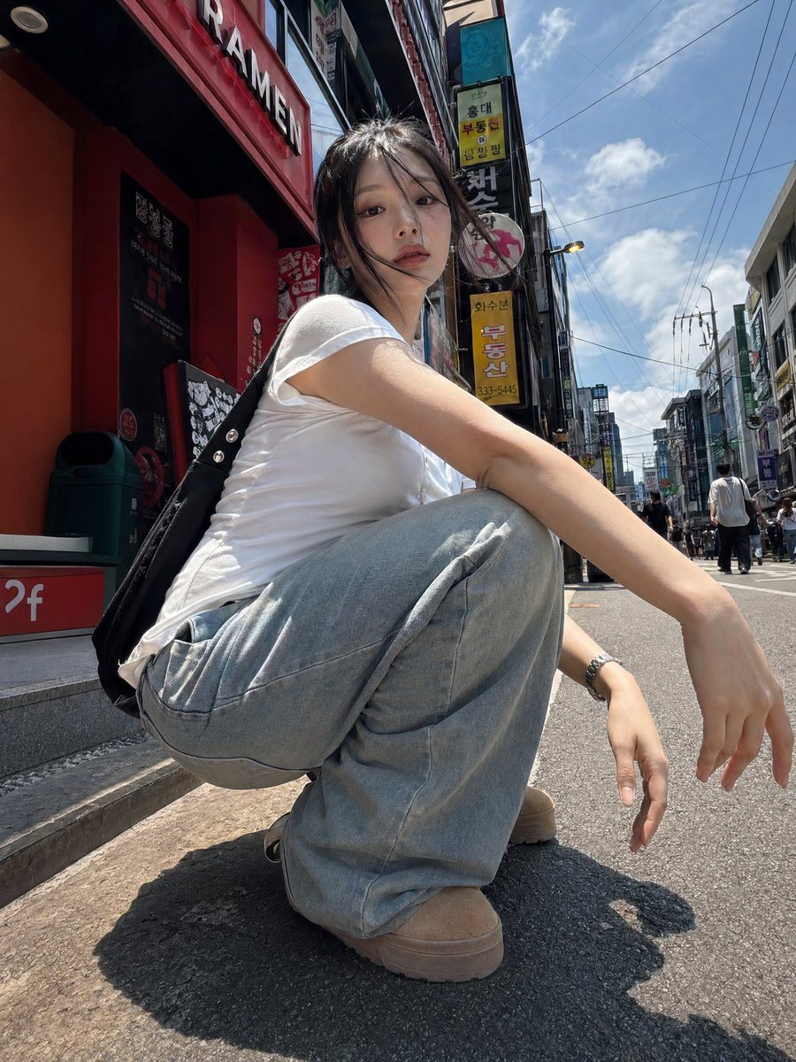 Street photography, sunlight, trendy Korean girl, 20s, squatting on the ground, strong perspective, Dynamic poses, low angle, shot with iPhone 17.