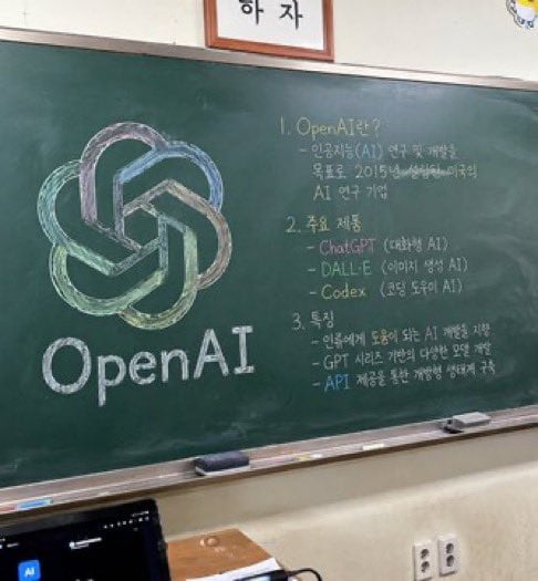 A photorealistic, slightly angled snapshot of a green classroom chalkboard. On the left side of the board is a large, meticulously drawn chalk illustration of the OpenAI logo, rendered in...