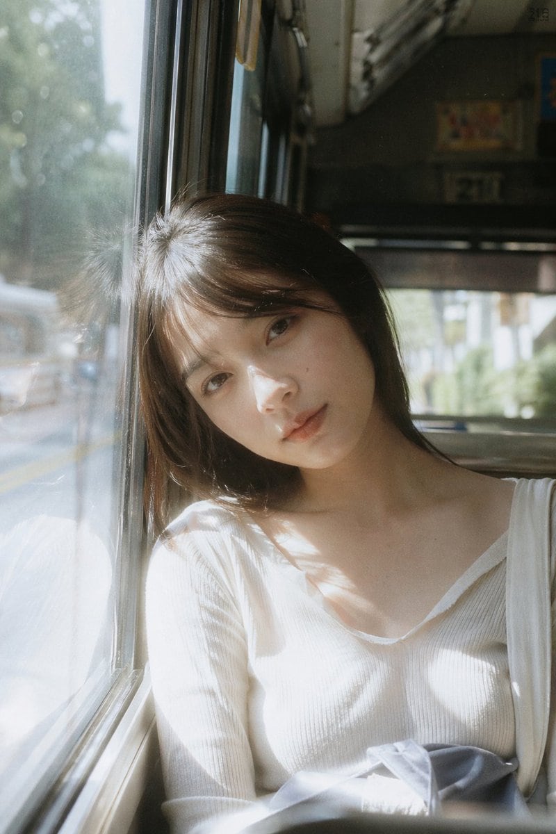 Japanese negative film aesthetic, bus window seat, soft daylight streaming in, slight overexposure highlights on face and window edges, low contrast, muted faded colors, subtle grain subj...