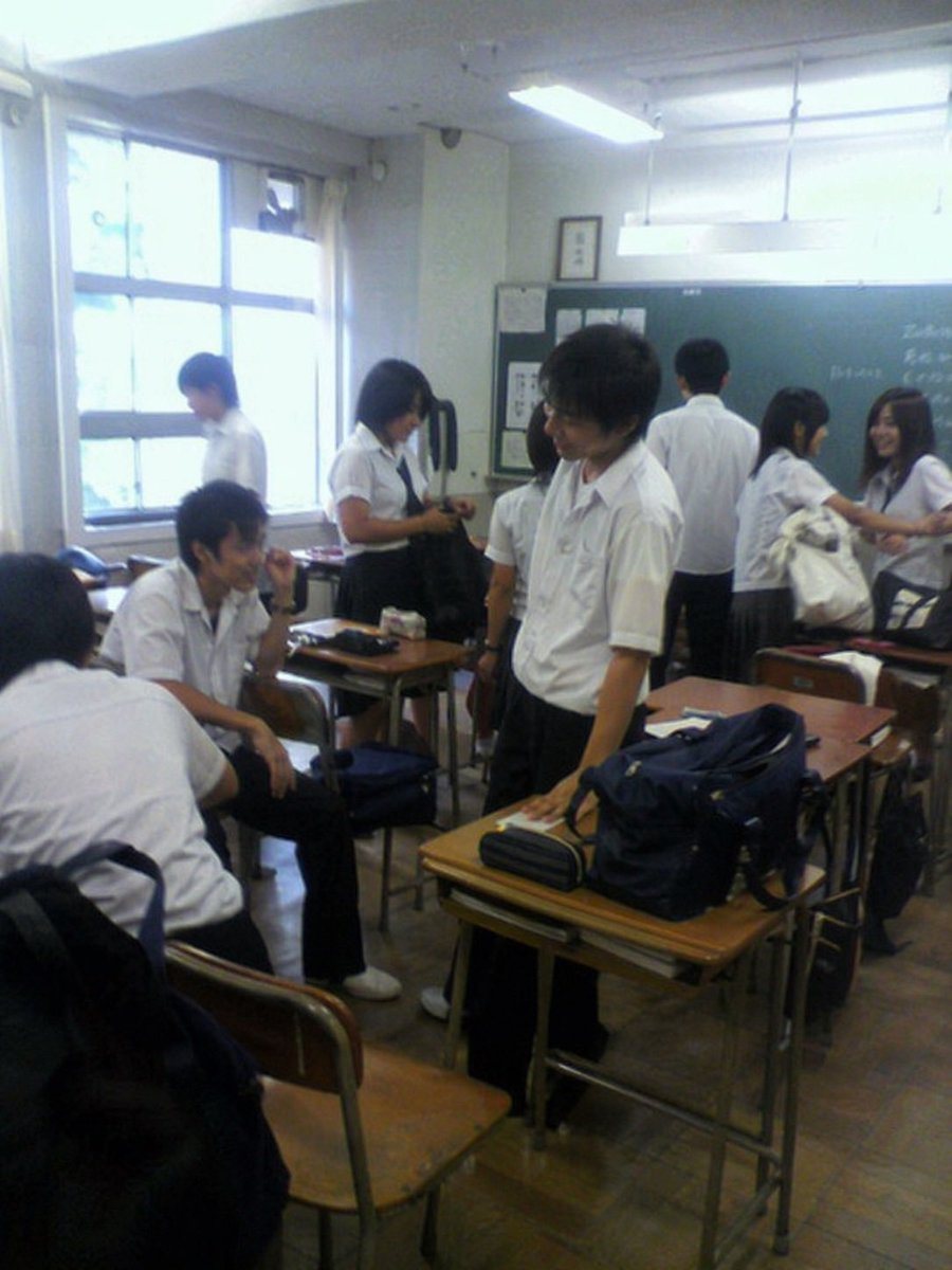 一个用于生成低画质、怀旧风格照片的高详细度提示词，描绘了放学后聚在一起的日本高中生，呈现出翻盖手机拍摄的质感。