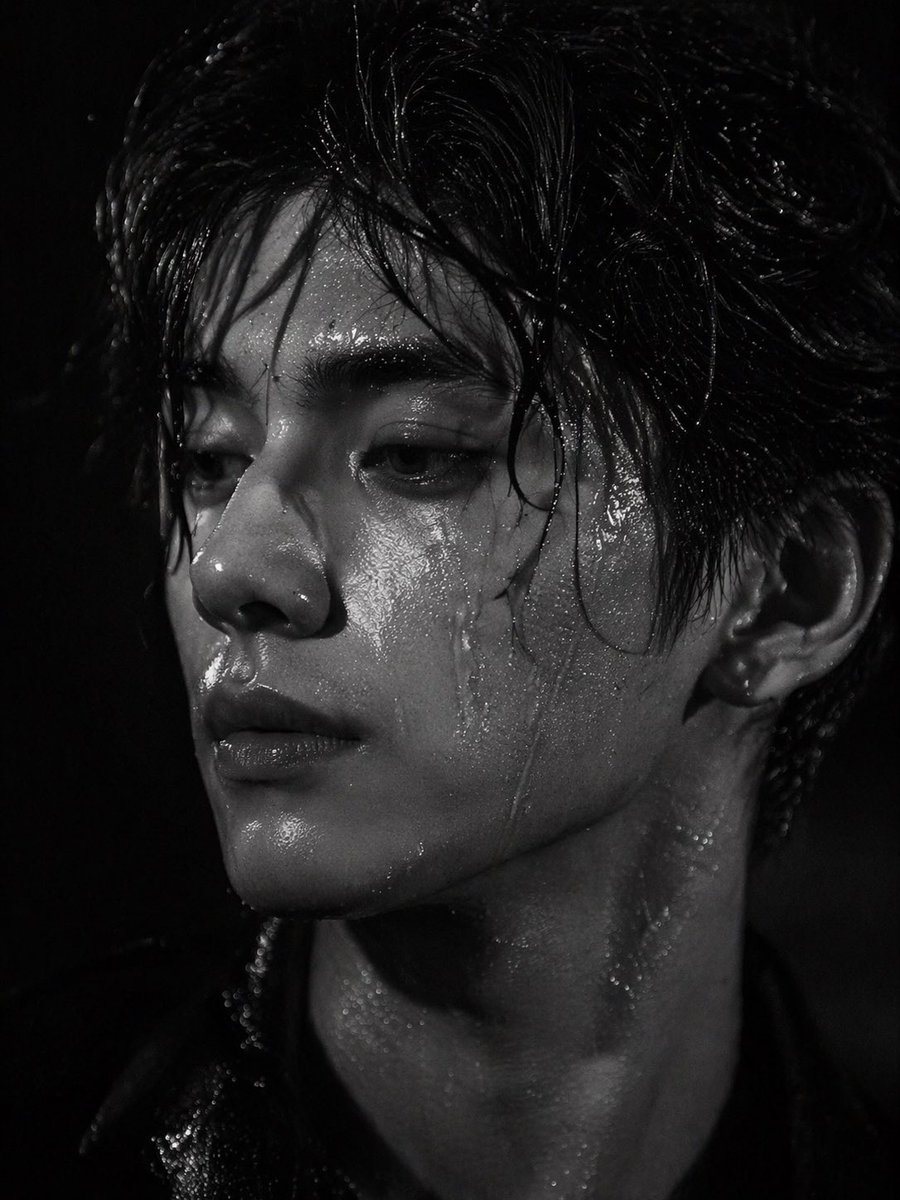 A striking black and white close-up portrait of a handsome young Asian man with messy wet hair sticking to his forehead. His face and neck are glistening, covered in highly detailed water...