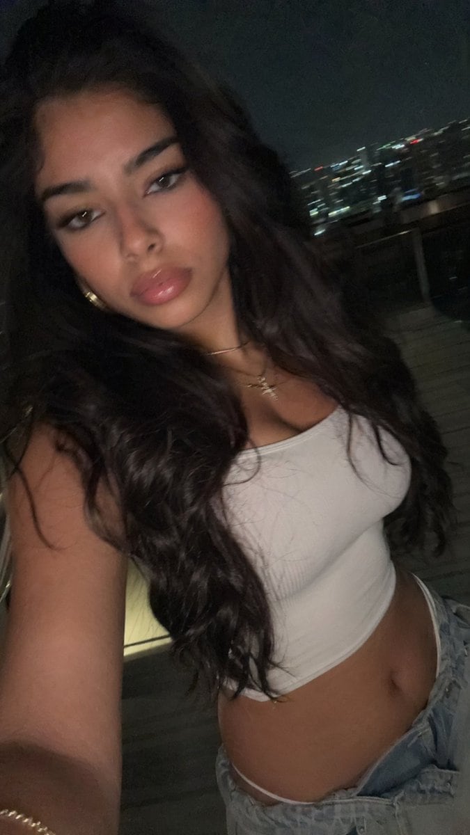 This prompt generates a realistic late-night balcony selfie with flash, ideal for casual social-media style portrait photography.