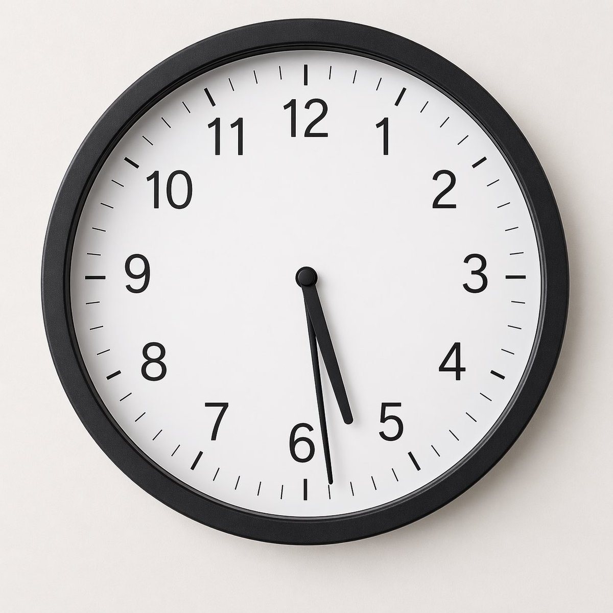 A minimalist studio photograph of a round analog wall clock mounted on a smooth light gray wall, centered in frame and viewed straight on. The clock has a matte black circular frame, a cl...