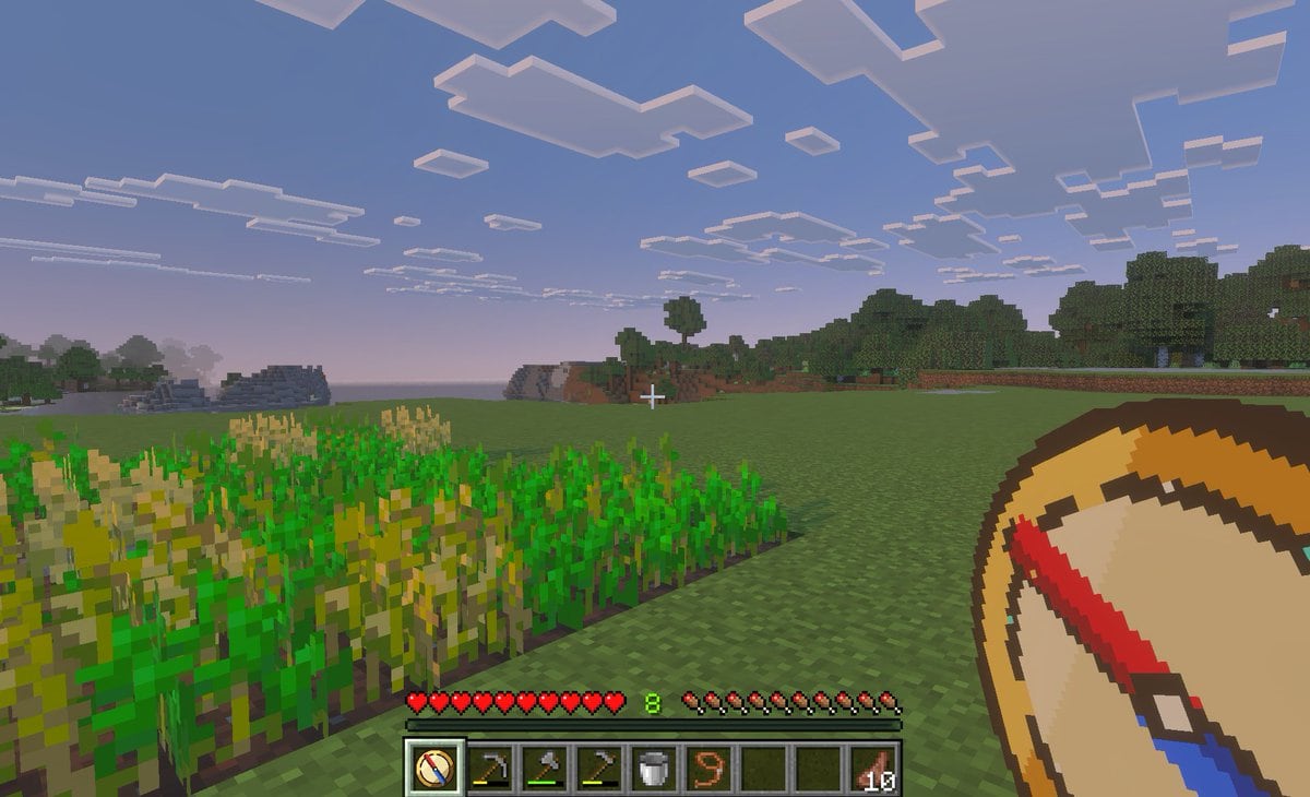 A first-person gameplay screenshot in the style of Minecraft Bedrock Edition at dusk, showing a peaceful grassy plains biome with a small rectangular wheat farm in the left foreground, so...