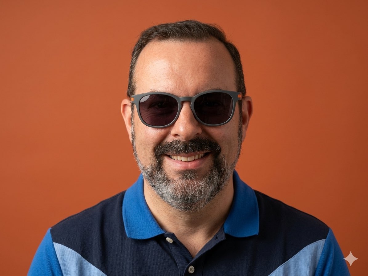 Using the provided reference image, keep the same person and the same blue polo shirt, but transform the casual poolside selfie into a clean professional studio head-and-shoulders portrai...