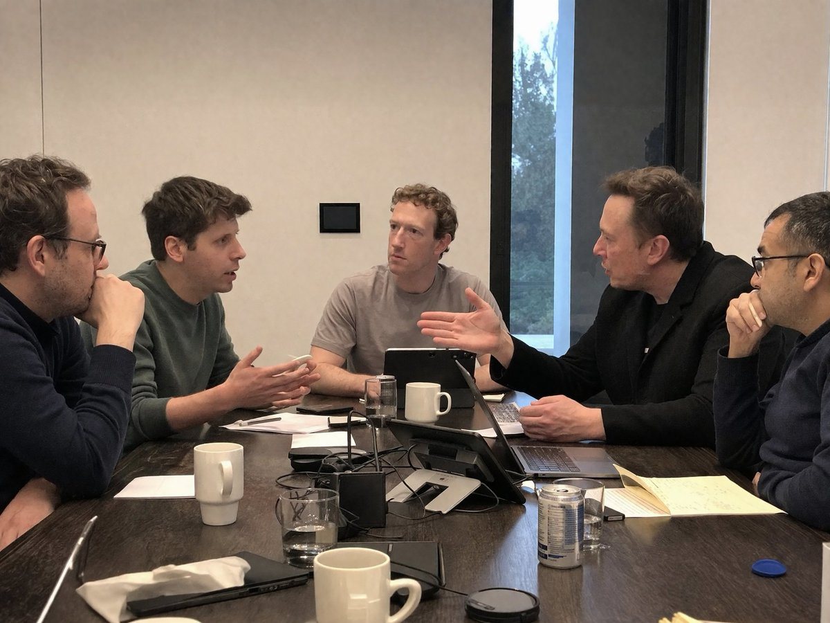 A candid, realistic smartphone photo of five men having an intense discussion around a dark wooden conference table in a modern, minimalist office. On the mid-left, a man resembling Sam A...