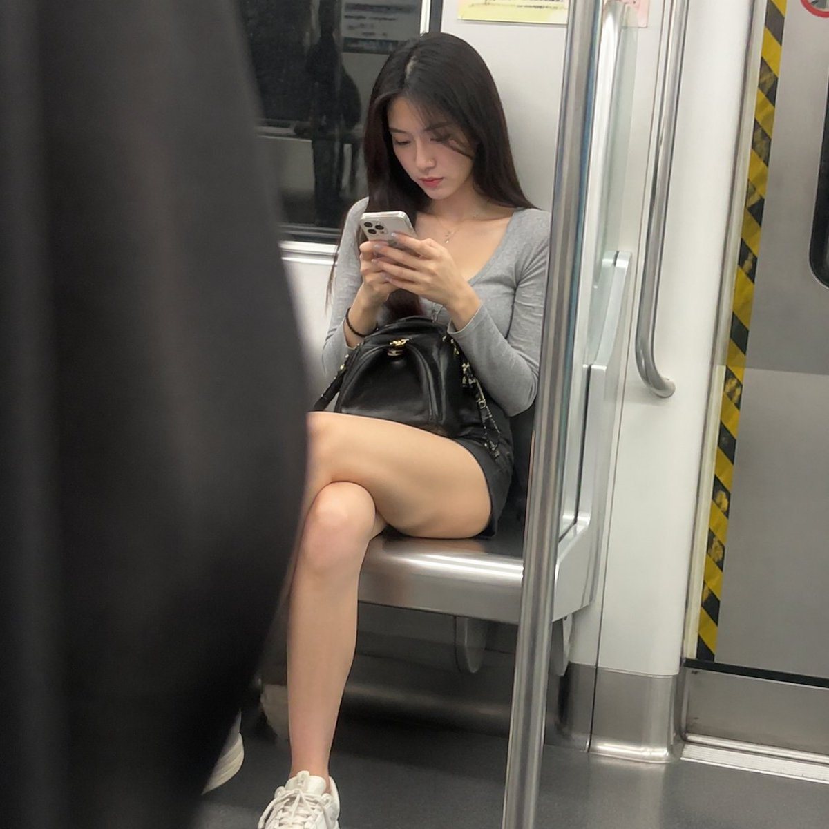 A beautiful woman looking at her phone on the subway; a candid photo.