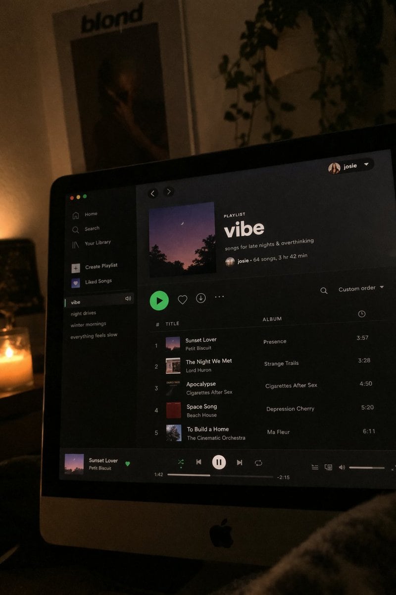 A photo of a computer screen displaying a Spotify playlist at night
