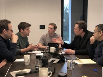 A candid, realistic smartphone photo of five men having an intense discussion around a dark wooden conference table in a modern, minimalist office. On the mid-left, a man resembling Sam A...